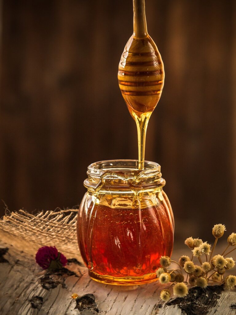 honey being dripped into a container | Busy Life Healthy Wife holistic healing practitioner